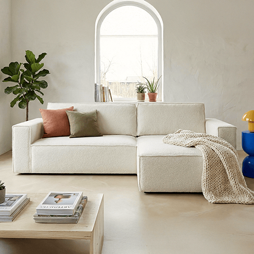 Canapé d'angle convertible réversible 4 places avec coffre de rangement en tissu bouclé beige- Livia